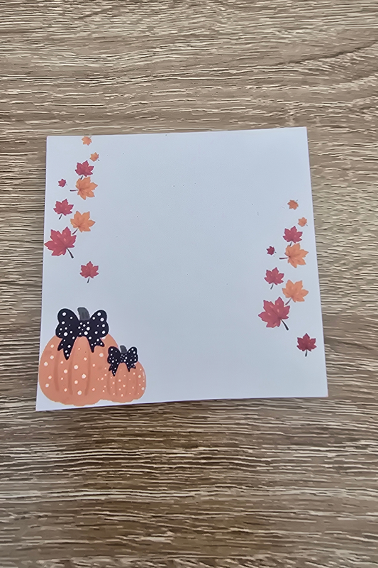 3 by 3 inch fall notepad with blank center, orange and red leaves, and two pumpkins with black bows