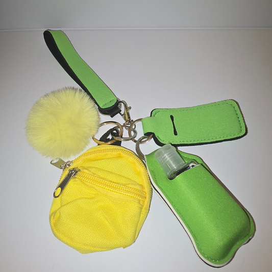 Green and yellow keychain accessory set with coin pouch hand sanitizer holder lip balm holder and pom pom